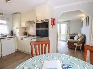 a kitchen and living room with a table and chairs at Seaward in Norwich