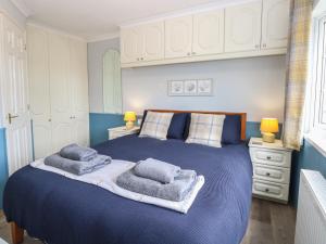 a bedroom with a blue bed with towels on it at Seaward in Norwich