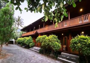 a building with bushes in front of it at Hotel Besar Bulan Baru Senggigi - Near Senggigi Beach in Senggigi