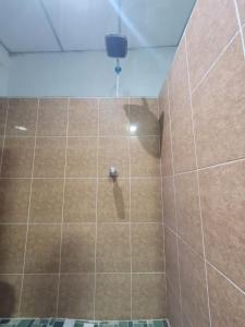 a bathroom with a shower with brown tile at Hospedaje céntrico in Zacatecoluca
