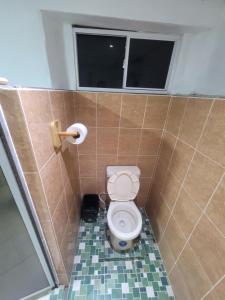 a bathroom with a toilet in a tiled stall at Hospedaje céntrico in Zacatecoluca