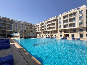 a large swimming pool in front of a building at Hurghada HuB in Hurghada