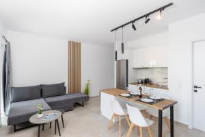 a kitchen and living room with a couch and a table at Naxos Cube Villa Panoramic Views Maisonette with Sea View 2 min walk to Plaka Beach in Plaka