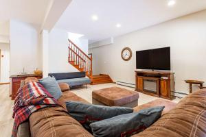 a living room with a couch and a flat screen tv at Kaaterskill Mountain House - 287 Acres with Fire Pit in Elka Park