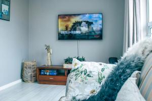 a living room with a couch and a tv on the wall at Lalandi 14 - Beachfront Self-Catering- Langstrand Walvis Bay in Langstrand