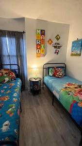 a bedroom with two beds and a table with a lamp at Cozy Getaway in Orlando