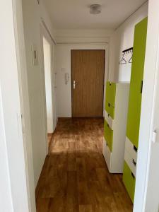 a hallway with green and white cabinets and a door at Máneska in Cheb
