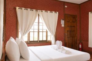a bedroom with a large white bed with a window at Jurisu Resort in San Vicente +41 photos