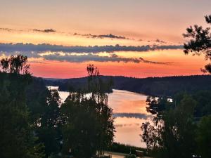 a view of a lake with trees and a sunset at Naturstugan in Nacka in Ormingelandet +2 photos