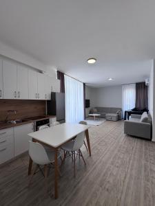 a kitchen and living room with a table and chairs at Angelo Apartments Ilyonis Residence in Shëngjin