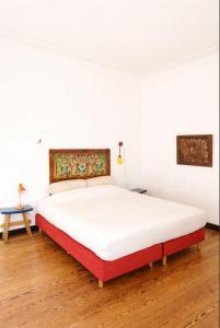 a bed in a room with white walls and wooden floors at villa marguerite in Lunas