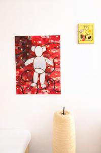 a painting of a mickey mouse hanging on a wall at villa marguerite in Lunas +25 photos