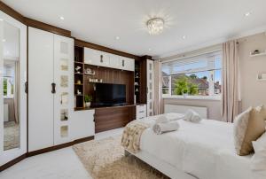 a bedroom with a large bed and a television at Spacious 4BR with Parking for Groups & Contractors in Solihull