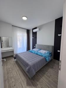 a bedroom with a bed and a mirror in it at Angelo Apartments Ilyonis Residence in Shëngjin