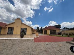 a house with a brick driveway in front of a building at Monti's Villa Suites in Southgate