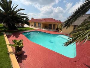a swimming pool in front of a house at Monti's Villa Suites in Southgate