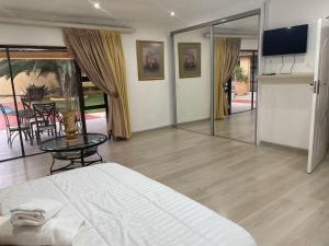 a bedroom with a bed and a table and a television at Monti's Villa Suites in Southgate +16 photos