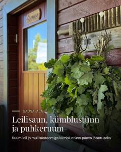 a door to a building with a large green bush at Pühajõe Puhkemaja in Pühajõe