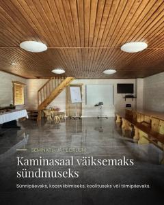 a living room with a wooden ceiling and a table at Pühajõe Puhkemaja in Pühajõe