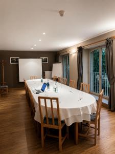 a conference room with a large white table and chairs at Au Bon Gîte in Senones +10 photos
