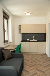 a living room with a couch and a kitchen at Apartmani Gradska in Prijepolje
