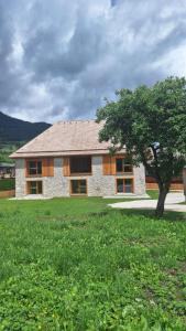 a building with a tree in front of a field at Urlaub im Denkmal in Gröbming