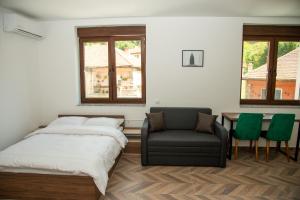 a bedroom with a bed and a chair and a table at Apartmani Gradska in Prijepolje