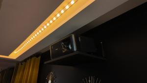 a television hanging from a ceiling with lights at L'Écrin d'Or - Spa - Cinéma privé in Saumur