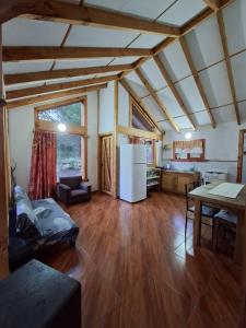 a large living room with a table and a refrigerator at Refugio entre Coihues in Melipeuco