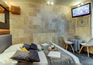 a bedroom with a bed and a flat screen tv at Sous mon toit - Sauna & jacuzzi in Dijon