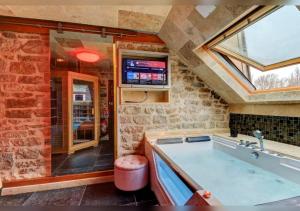 a bathroom with a large bath tub with a window at Sous mon toit - Sauna & jacuzzi in Dijon