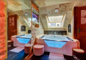 a large bathroom with two tubs and a window at Sous mon toit - Sauna & jacuzzi in Dijon +7 photos