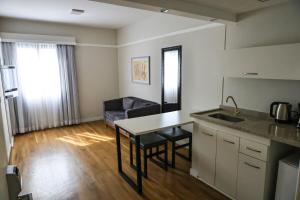 a kitchen and living room with a table and a couch at Ninety Hotel in São Paulo