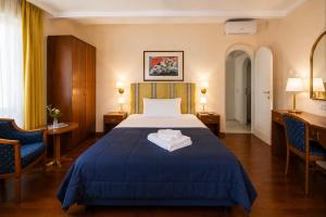 ein Hotelzimmer mit einem Bett und zwei Stühlen in der Unterkunft Hotel Posta in Cecina + 36 Fotos