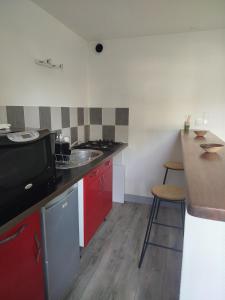 a small kitchen with red cabinets and a counter top at Studio in Blois