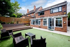 a backyard with a lawn with chairs and a house at Spacious 4BR with Parking for Groups & Contractors in Solihull
