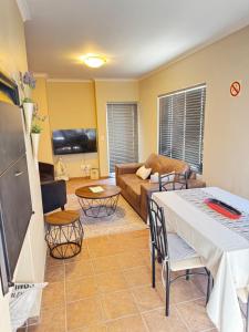 a living room with a table and a couch at Praia Longa 4 in Rand Rifles