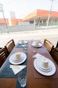 a wooden table with plates and napkins on it at AIRPORT HOTEL GRU LTDa in Guarulhos