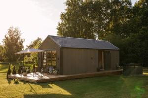 a small shed with a table and chairs in a yard at Ruoliškis tiny house in Biržai +13 photos
