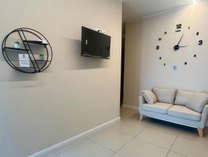 a room with a couch and a clock on the wall at Caraceni Apartaments 2 in Castel di Sangro
