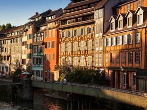 a group of buildings next to a river with a bridge at Mercure Strasbourg Centre in Strasbourg