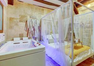 a bathroom with a tub and a shower with curtains at Bed & Spa - La Parenthese in Dijon