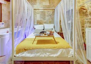 a bedroom with a canopy bed with a tray of food on it at Bed & Spa - La Parenthese in Dijon