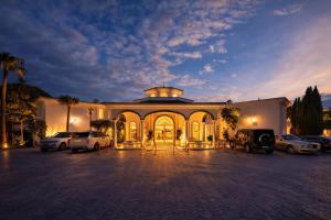 a large building with cars parked in a parking lot at Palacio Suites Marbella in Marbella