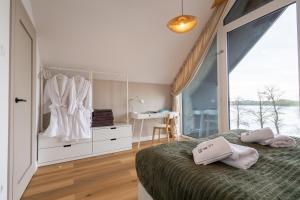 a bedroom with a bed and a dresser and a window at Sen Topoli - Domy nad jeziorem I Sauna I Plaża I 30 min od Torunia in Mirakowo +157 photos