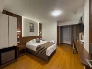 a bedroom with a bed and a flat screen tv at Hotel Yanahuara Suite in Arequipa