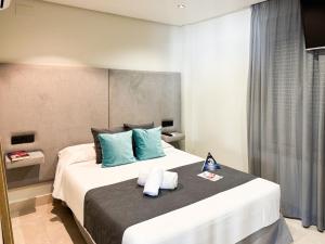 a bedroom with a large bed with blue pillows at ON City Apartments in Matalascañas +47 photos