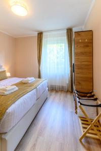 a bedroom with a large bed and a window at Kaposvár Deluxe Apartman in Kaposvár