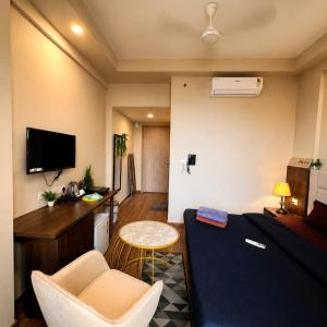 a room with a bed and a table and a desk at Glow Corner in Greater Noida