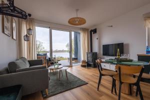 a living room with a couch and a table at Sen Topoli - Domy nad jeziorem I Sauna I Plaża I 30 min od Torunia in Mirakowo